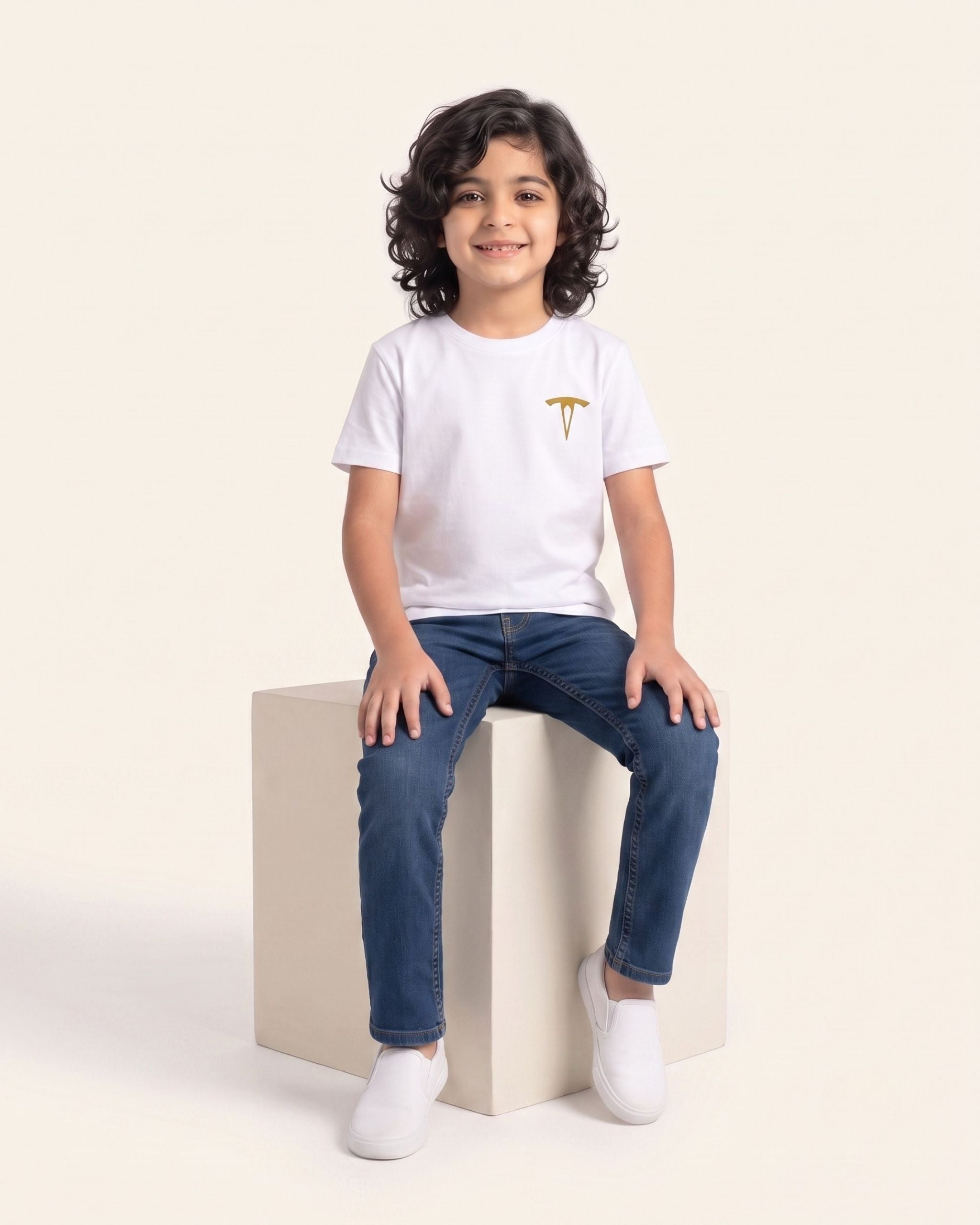 Boy sitting wearing a white OUTCAST basic tee with jeans