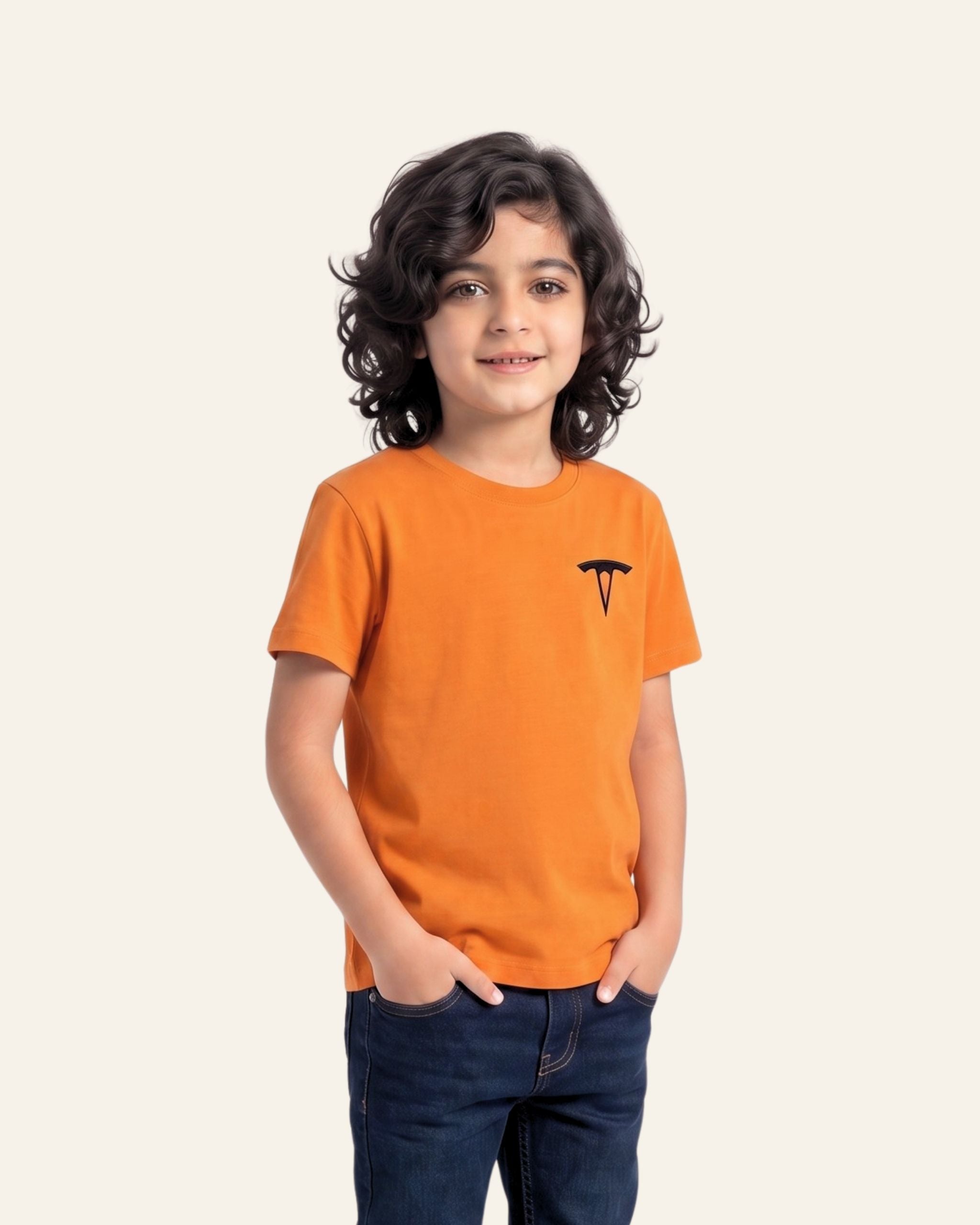 Boy wearing an orange OUTCAST basic tee with jeans