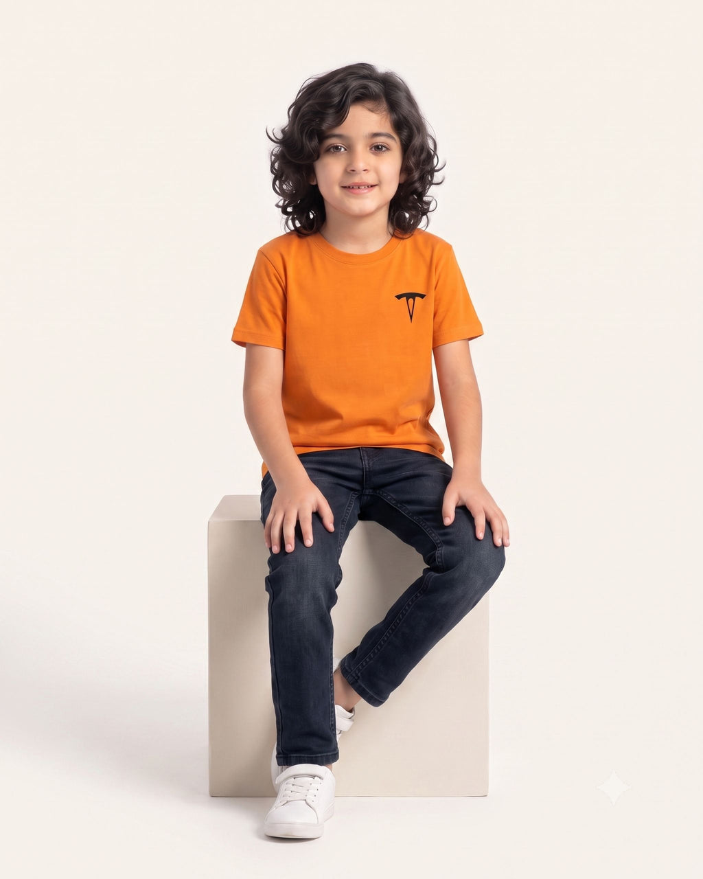 Boy sitting wearing an orange OUTCAST basic tee