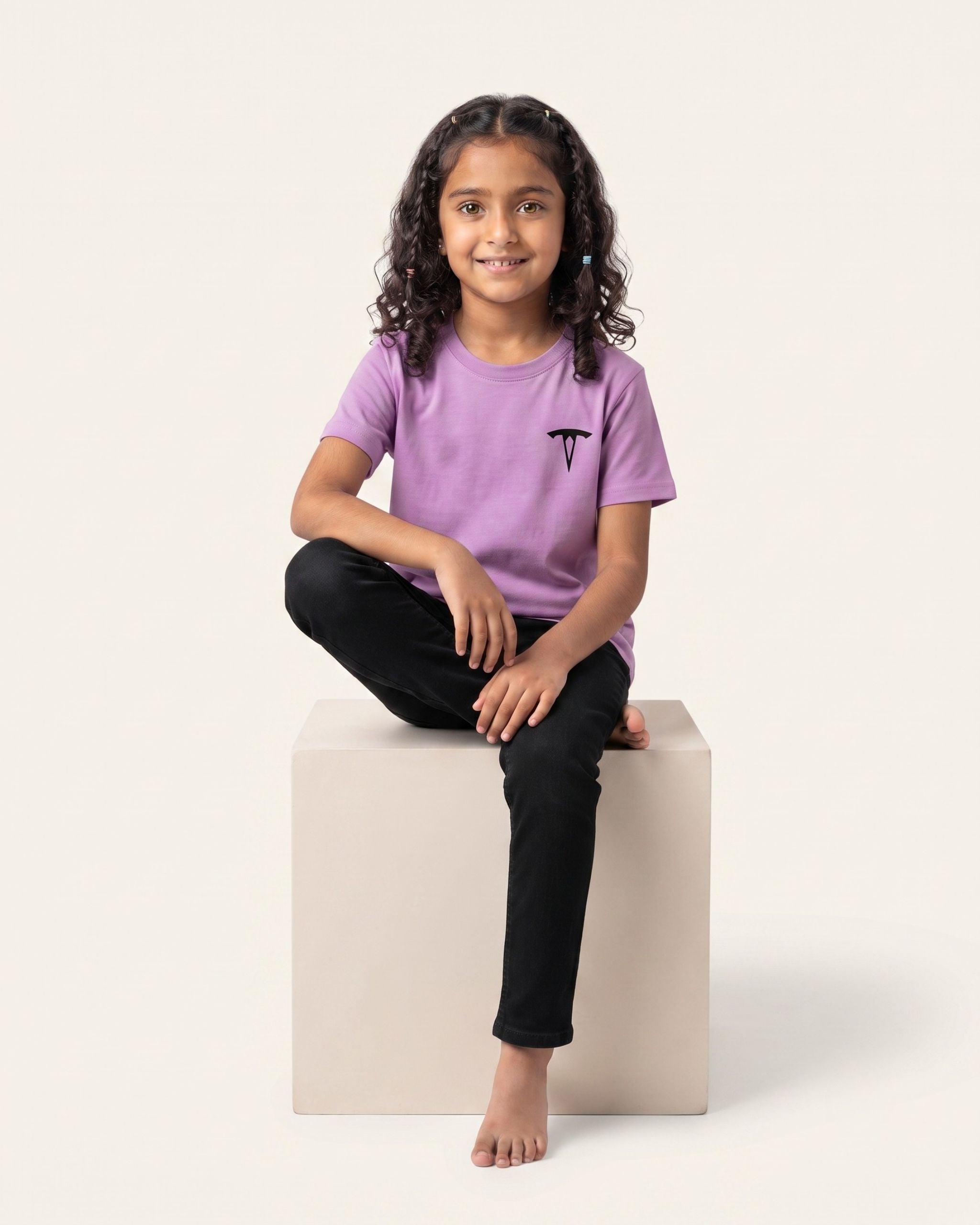 Girl sitting wearing an orchid OUTCAST basic tee