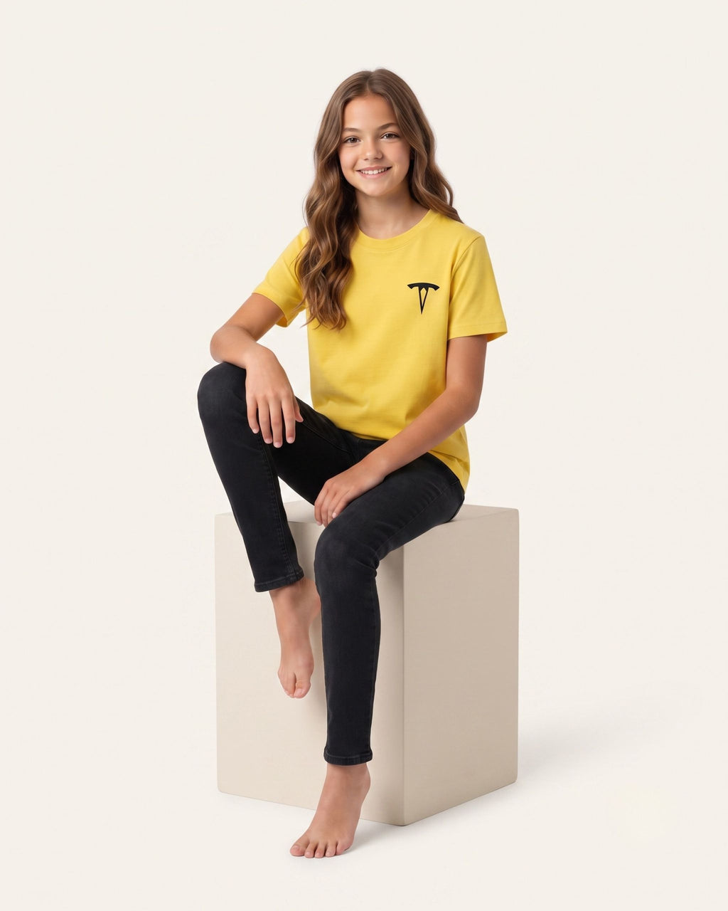 Girl sitting wearing a yellow OUTCAST basic tee