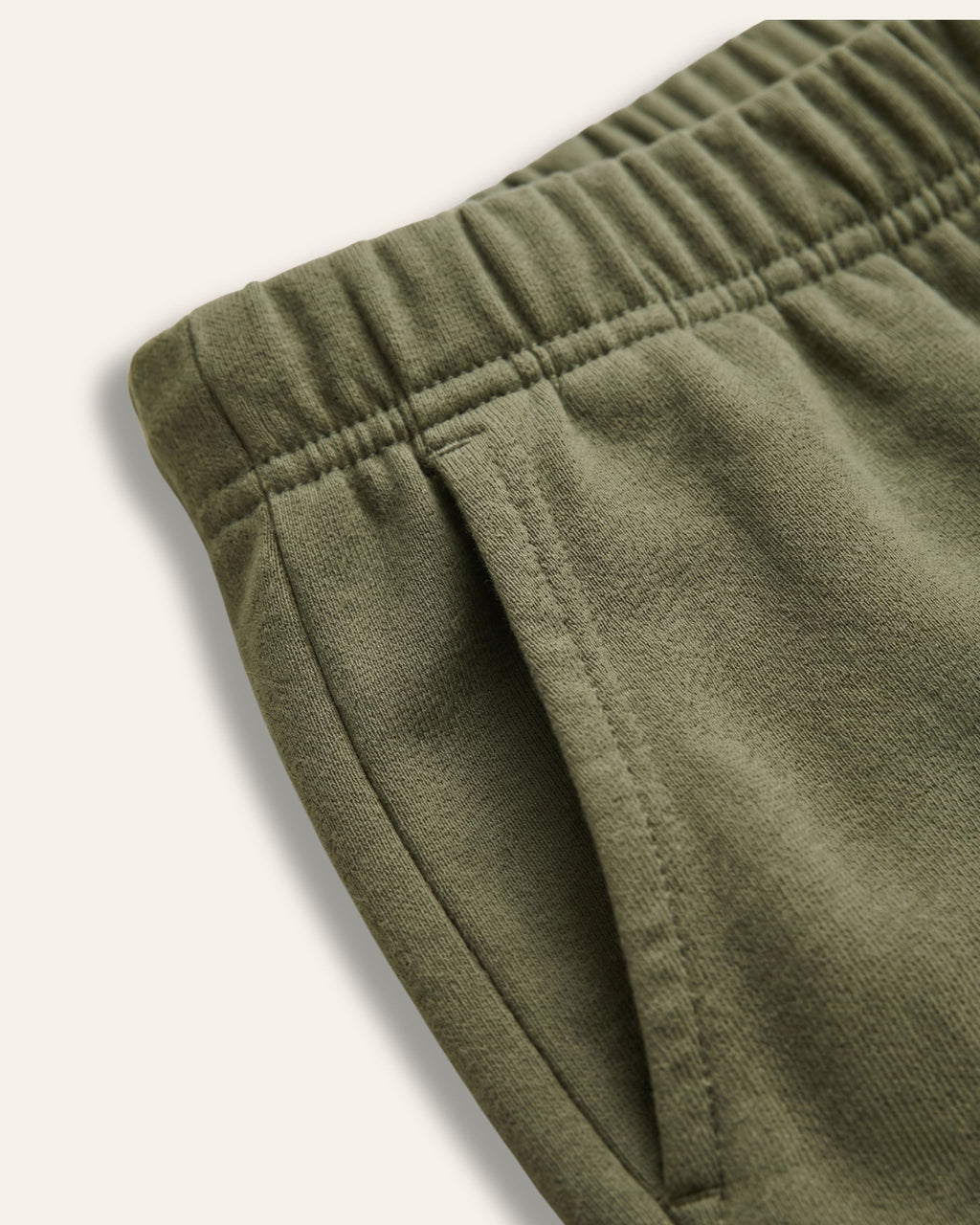 Close-up of the elastic waistband on olive kids shorts
