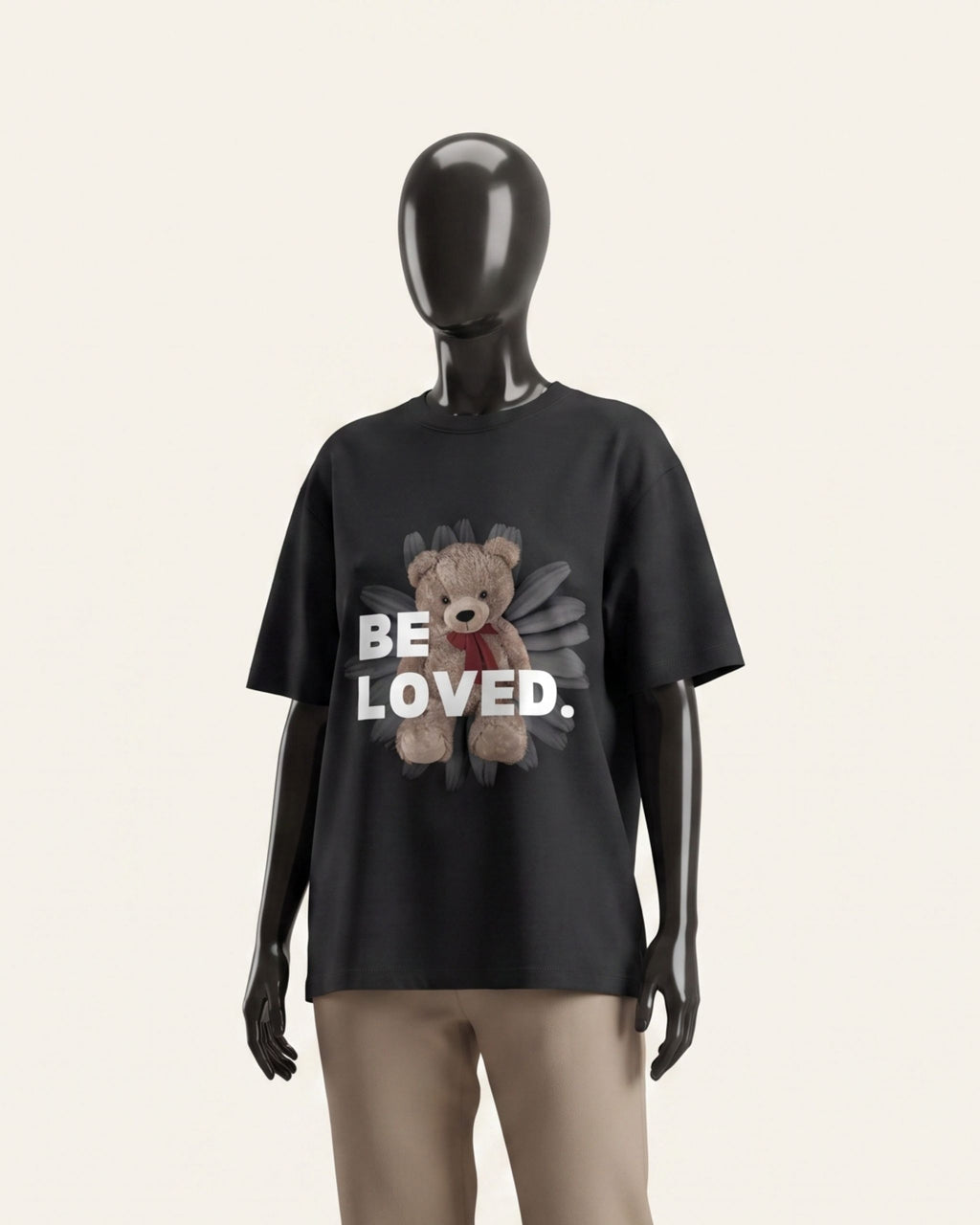 Woman wearing a black cotton tee with a teddy bear and BE LOVED wordmark print