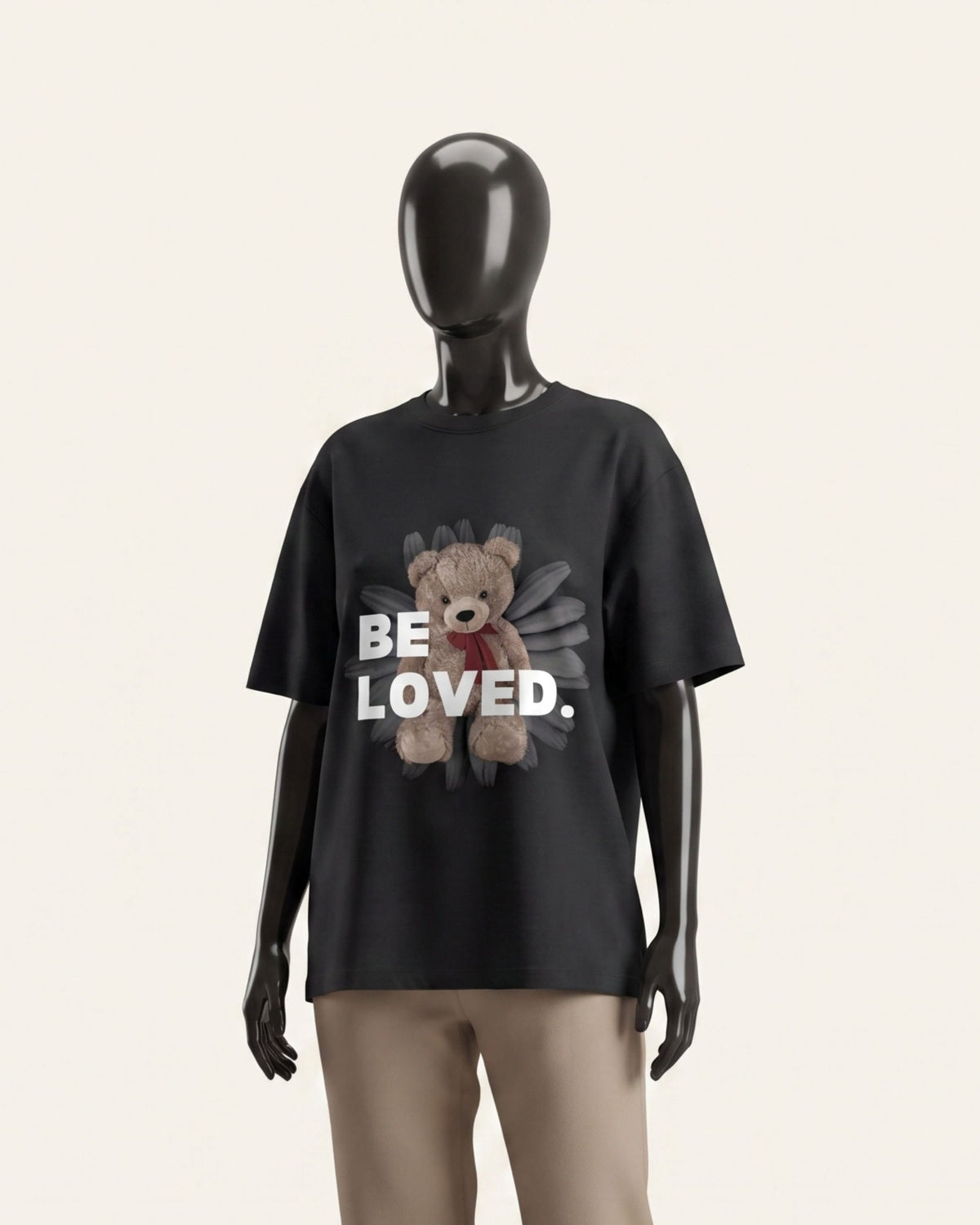 Woman wearing a black cotton tee with a teddy bear and BE LOVED wordmark print