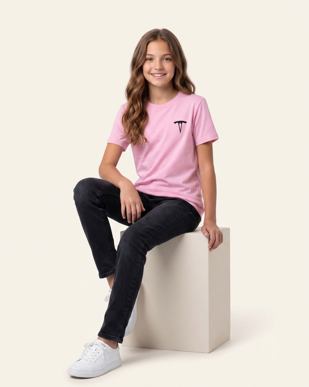 Girl sitting wearing a pink OUTCAST basic tee with black jeans