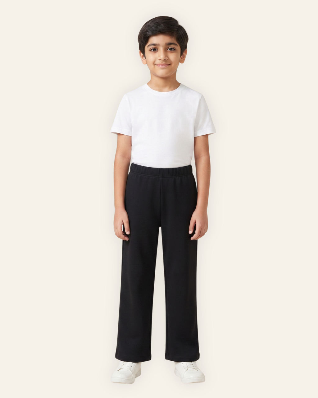 Boy wearing black OUTCAST kids trousers with a white tee