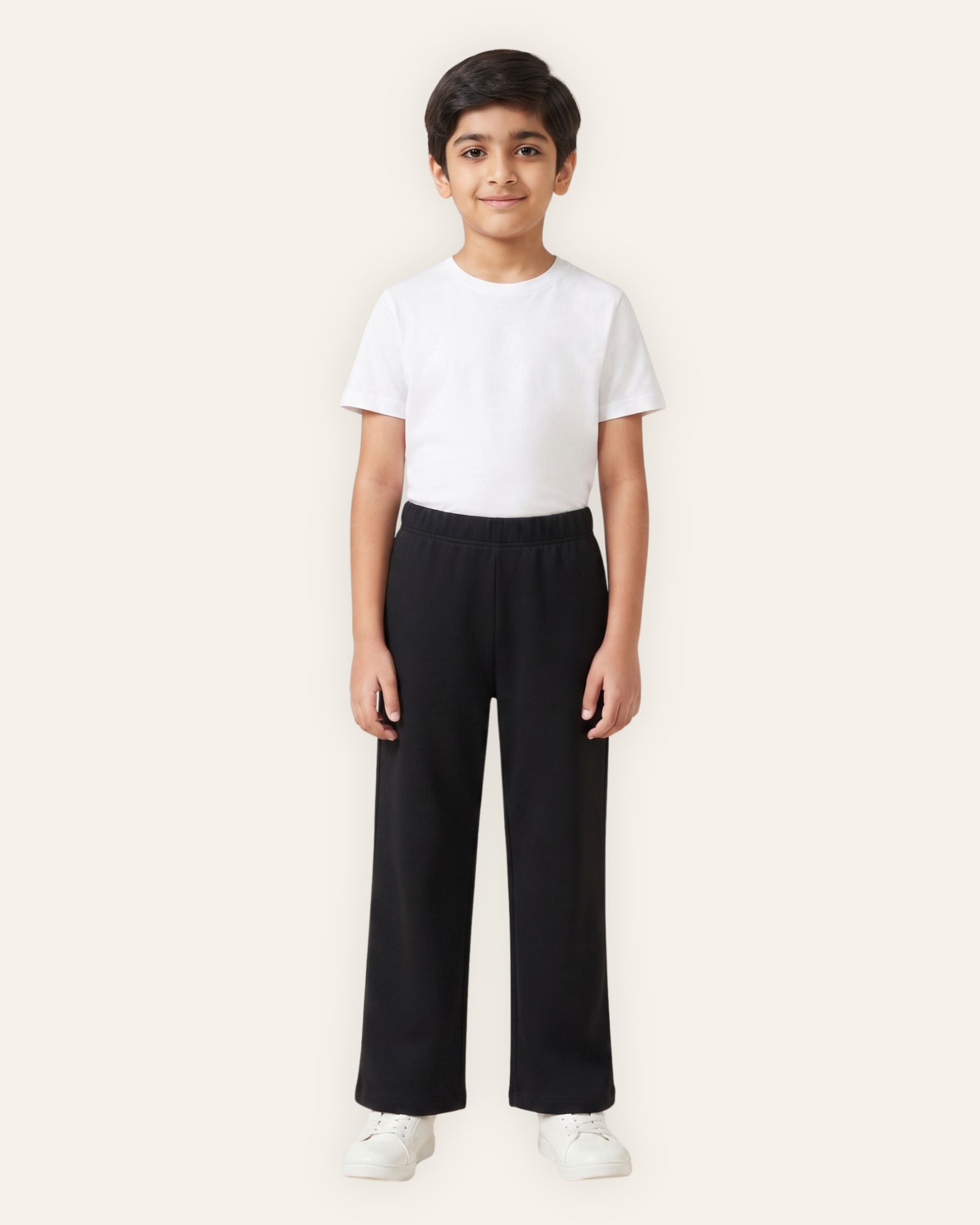 Boy wearing black OUTCAST kids trousers with a white tee