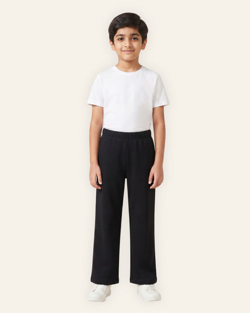 Boy wearing black OUTCAST kids trousers with a white tee