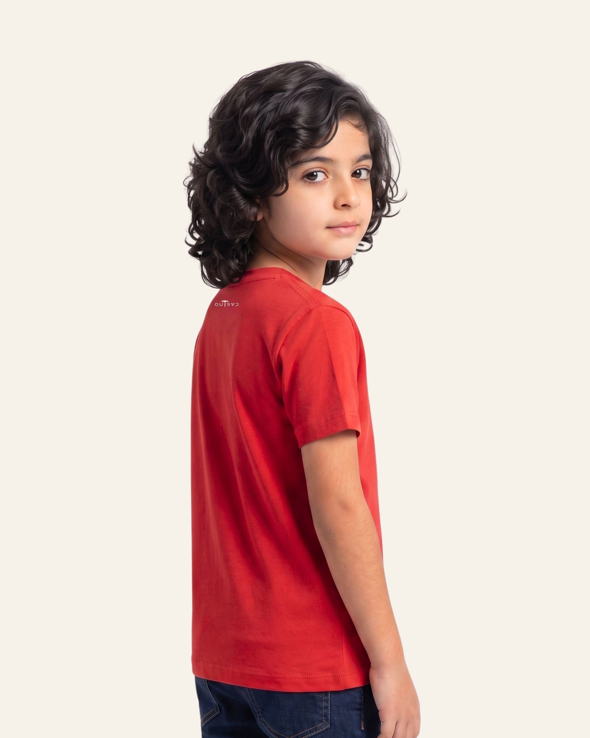 Boy wearing a red OUTCAST basic tee, side view